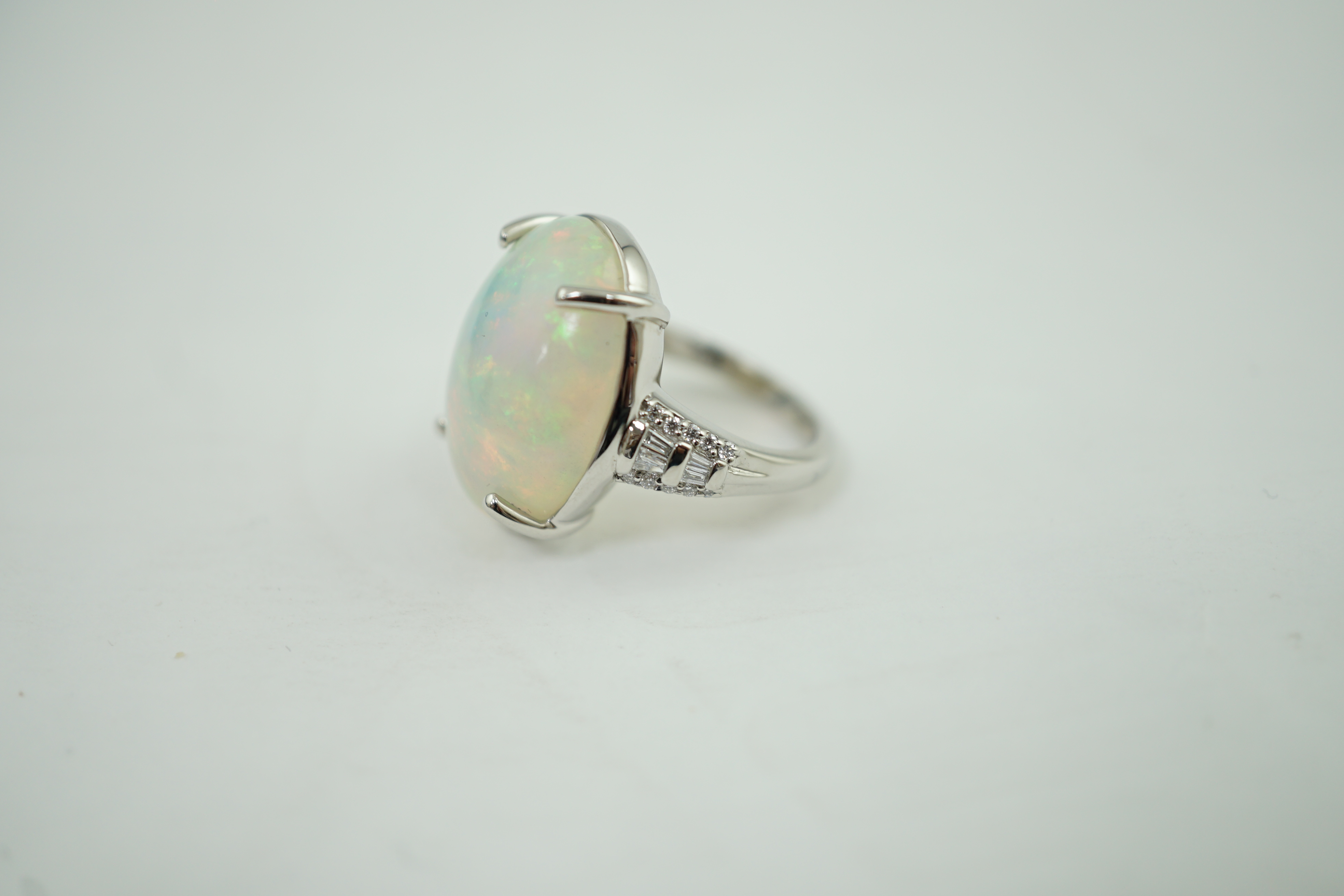 A modern Rhapsody platinum and opal white oval set dress ring, with trapeze and round cut diamond cluster set shoulders